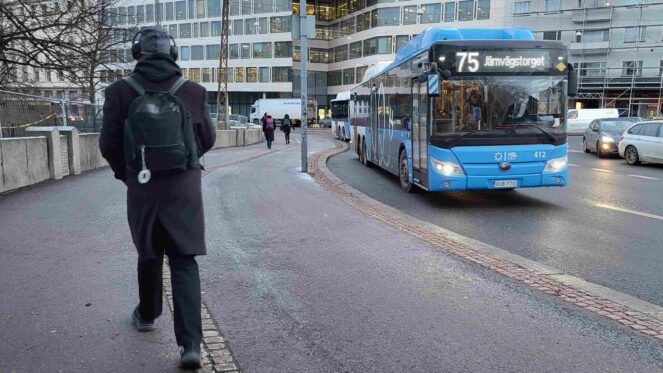 Jalankulkija ja HSL:n linja-auto 75 kadulla.