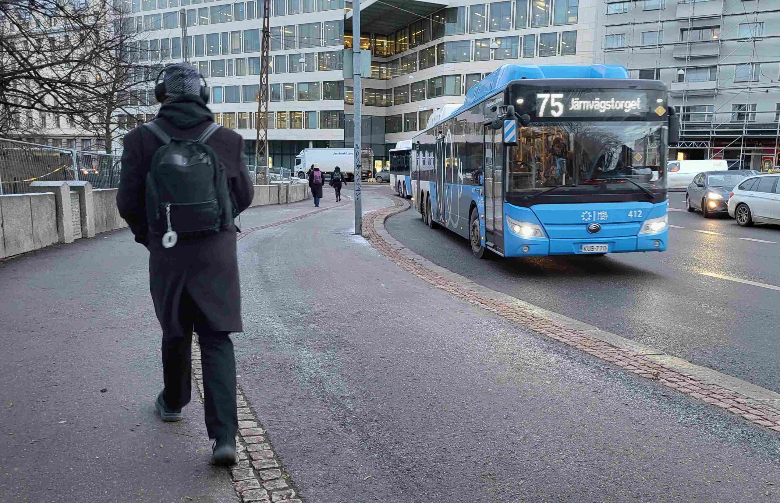 Jalankulkija ja HSL:n linja-auto 75 kadulla.