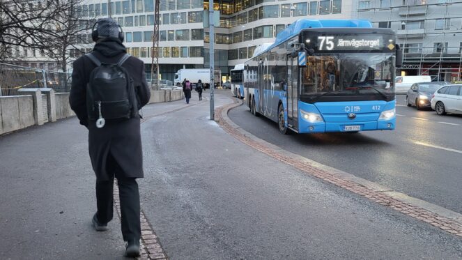 Linja-auto liikenteessä. Kävelijä.