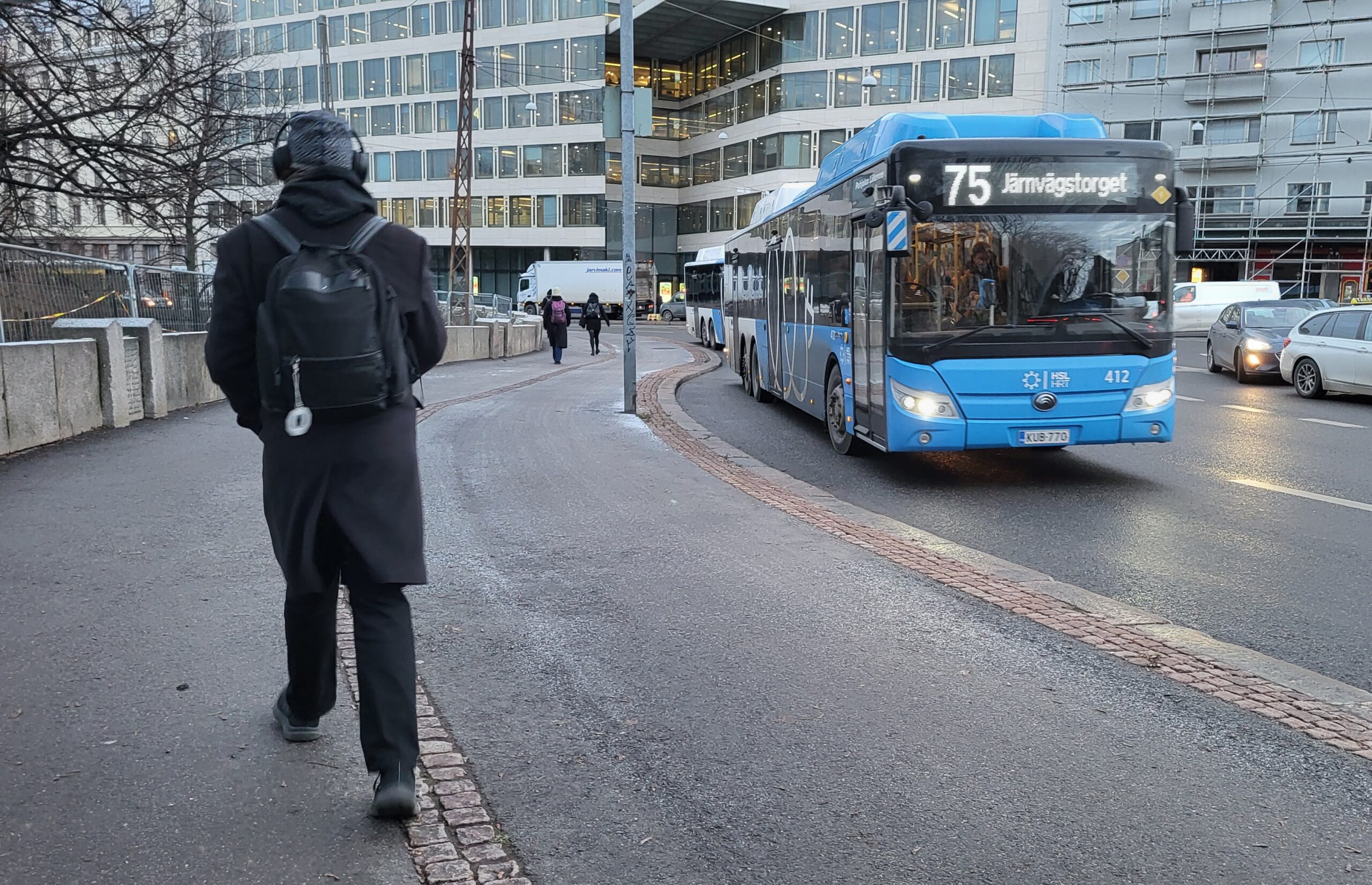 Linja-auto liikenteessä. Kävelijä.