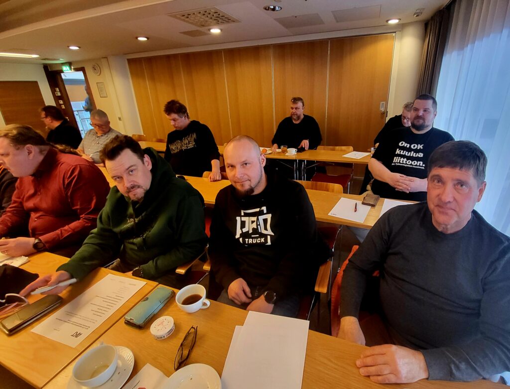 Mikko Mäkelä, Markus Taipale ja Esa Saarinen istuvat pöydän ääressä osana kokousporukkaa.