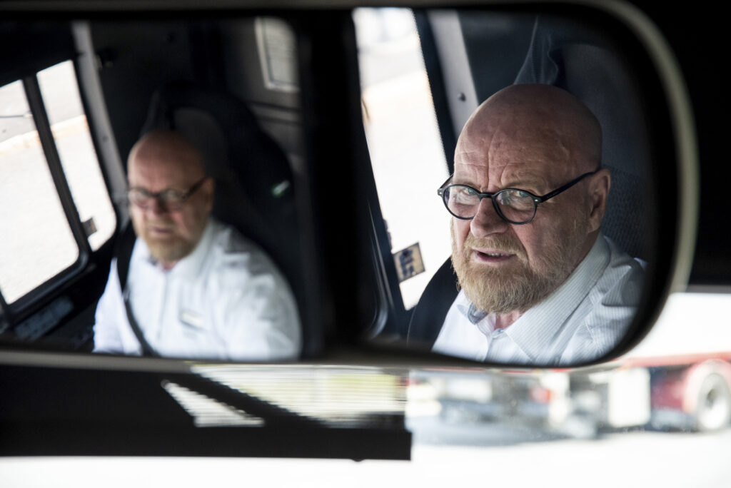 Kuvassa näkyy Pertti Piirinen kaksi kertaa bussin peilin kautta.