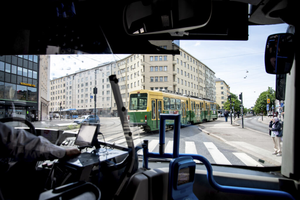 Kuva otettu bussin etuikkunan kautta. Kuvassa näkyy raitiovaunu.