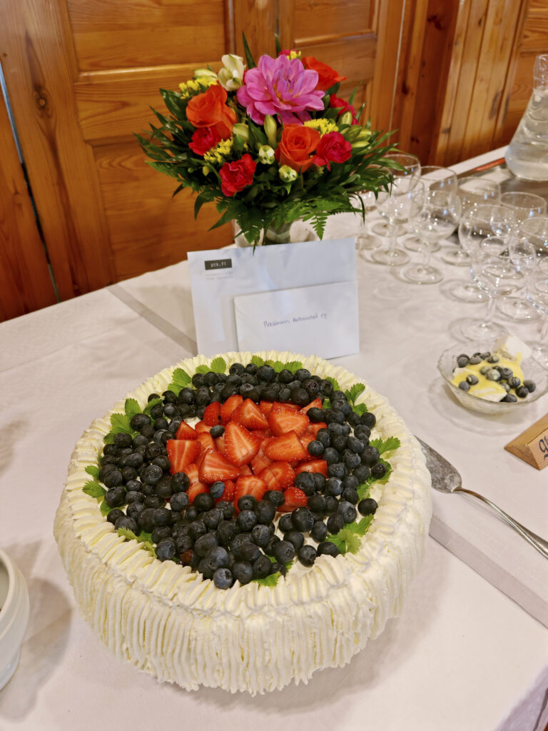 Kuvassa mansikkakermakakku juhlallisesti katetulla pöydällä.