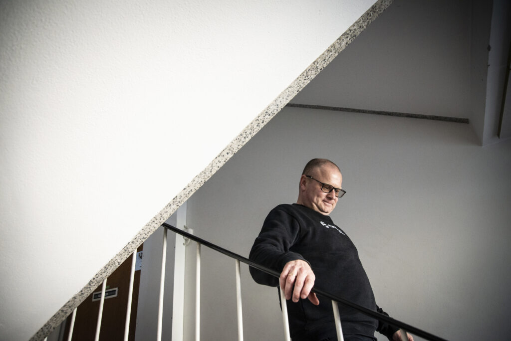 Mies kävelee rappusia alas rappukäytävässä.