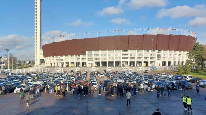 Olympiastadionin parkkipaikalla kymmeniä Bolt ja Uber-takseja, joiden kuljettajat ovat osoittamassa mieltään.